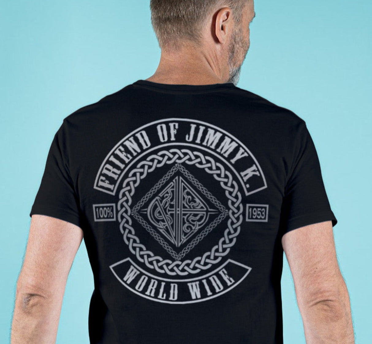 Man wearing a black t-shirt with a graphic design on the back against a light blue background