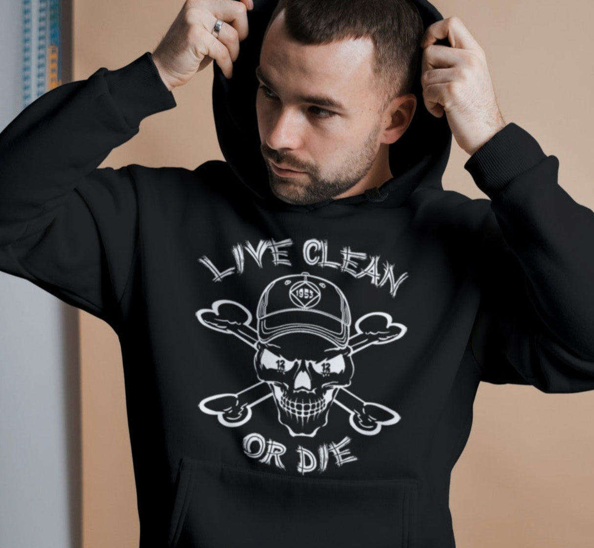 A person wearing a black hoodie with the text 'LIVE CLEAN OR DIE' and a graphic of a skull and crossbones on the front.