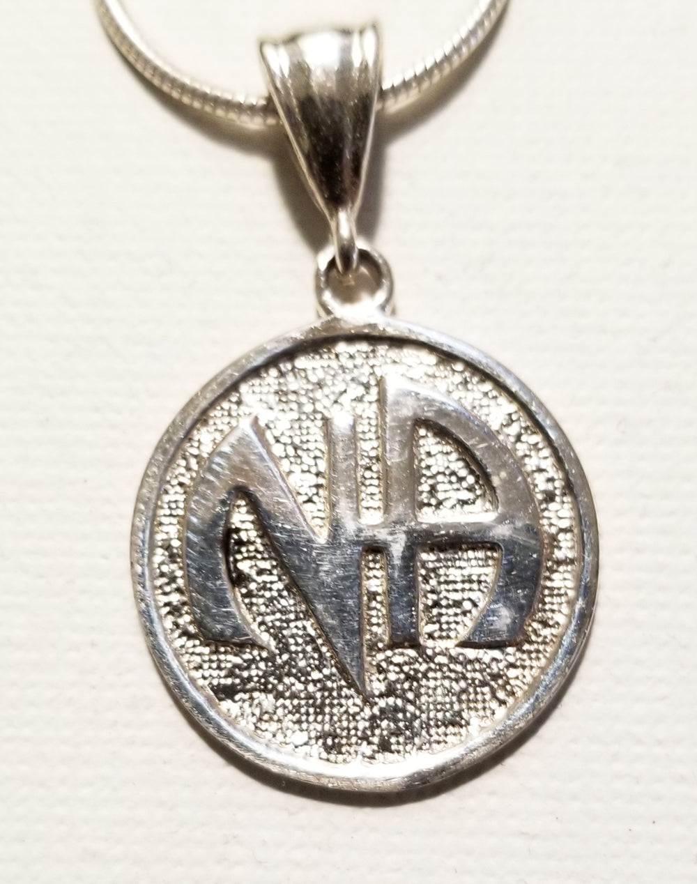 ssj003- Nickel Size NA Symbol Pendant