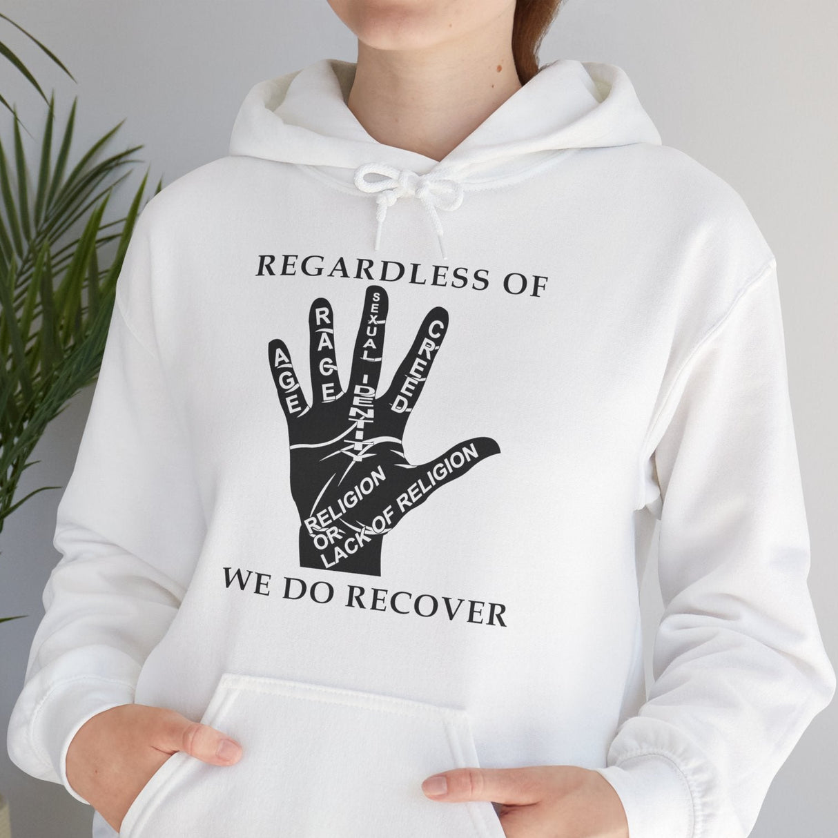 White hoodie with a graphic design and text, worn by a person, against a neutral background.