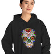 Person wearing a black hoodie with a colorful skull design on a white background