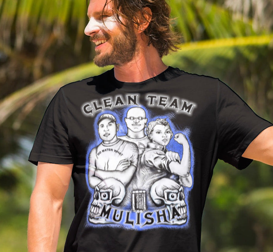 Man wearing a black t-shirt with graphic design and text, standing outdoors with palm trees in the background.