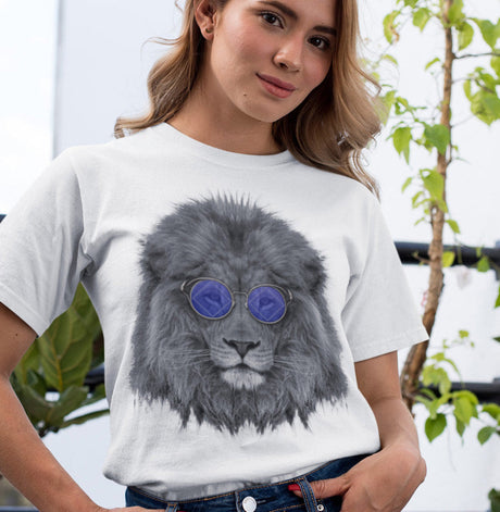 Woman wearing a white t-shirt with a graphic of a lion wearing sunglasses, standing outdoors.