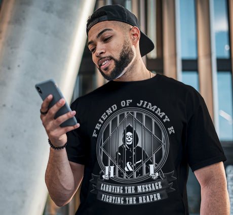Man wearing a black t-shirt with graphic design and text, looking at his phone.