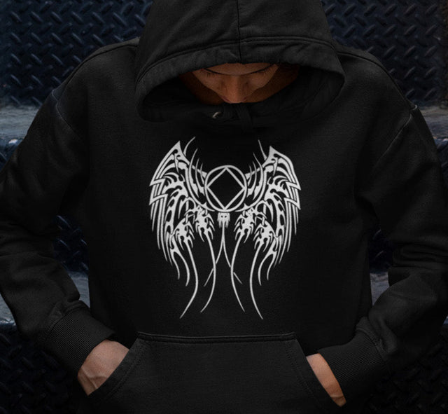 Person wearing a black hoodie with a white graphic design sitting on dark steps.