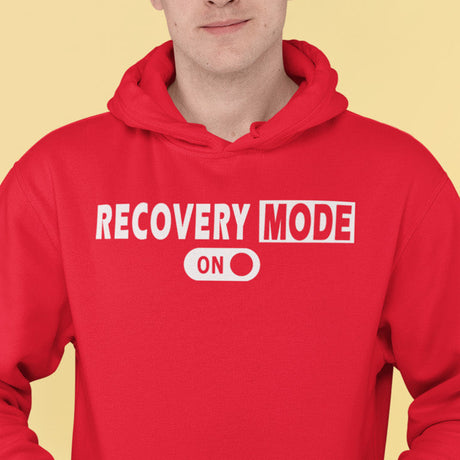 Person wearing a red hoodie with 'RECOVERY MODE ON' text on a yellow background