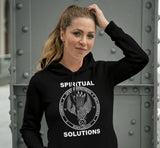 Woman wearing a black hoodie with 'Spiritual Solutions' text and design, standing against a metallic background.